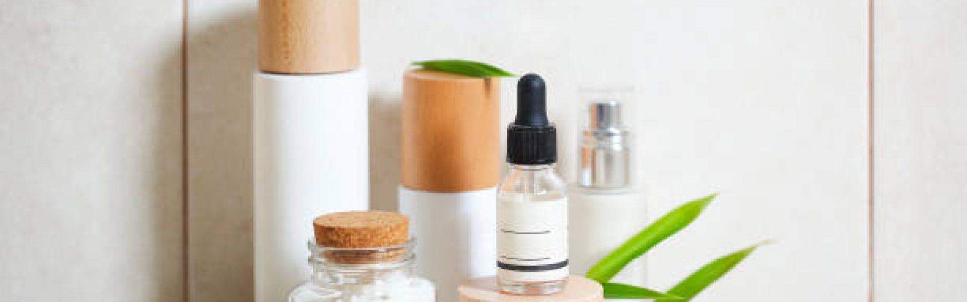 Face cream, serum, lotion, moisturizer and sea salt  among bamboo leaves in the bath